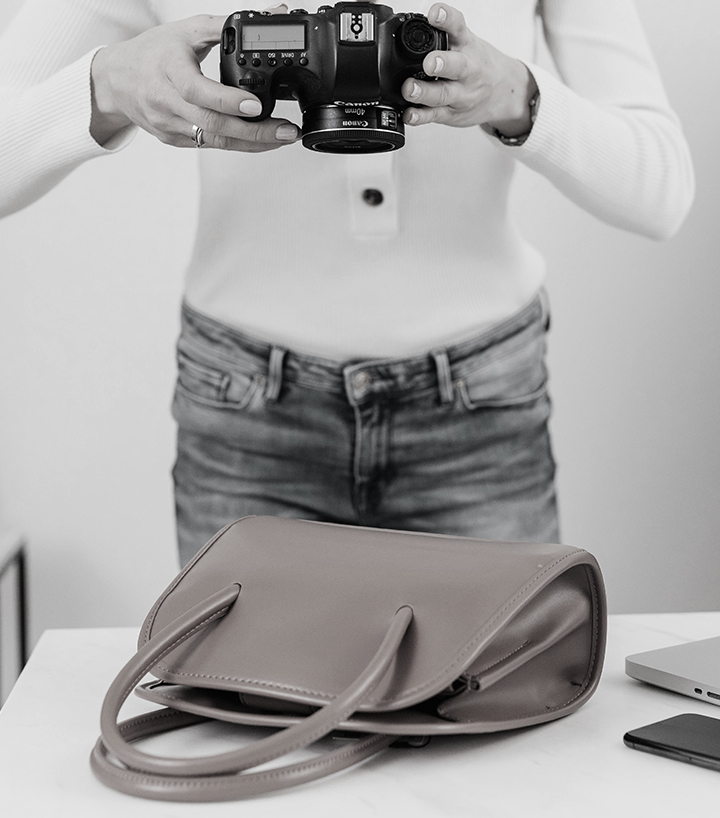 Donna fotografa una borsa per digitalizzare e alimentare l'archivio digitale dell'azienda