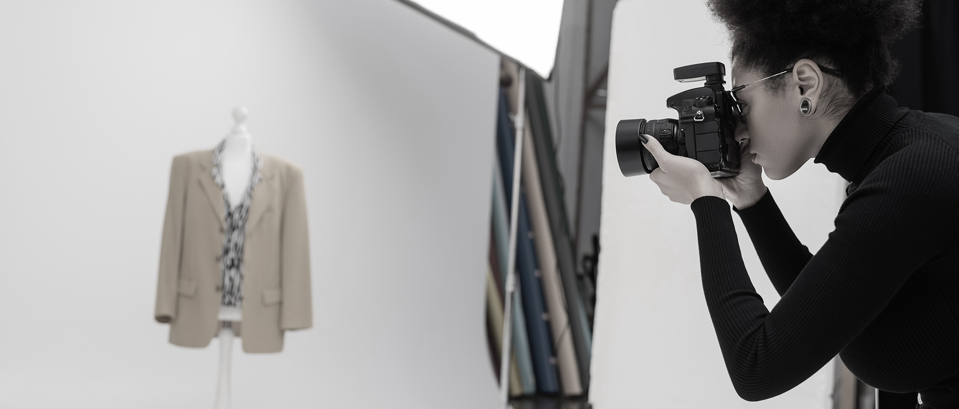 Donna fotografa un outfit su manichino per digitalizzare e alimentare l'archivio digitale dell'azienda