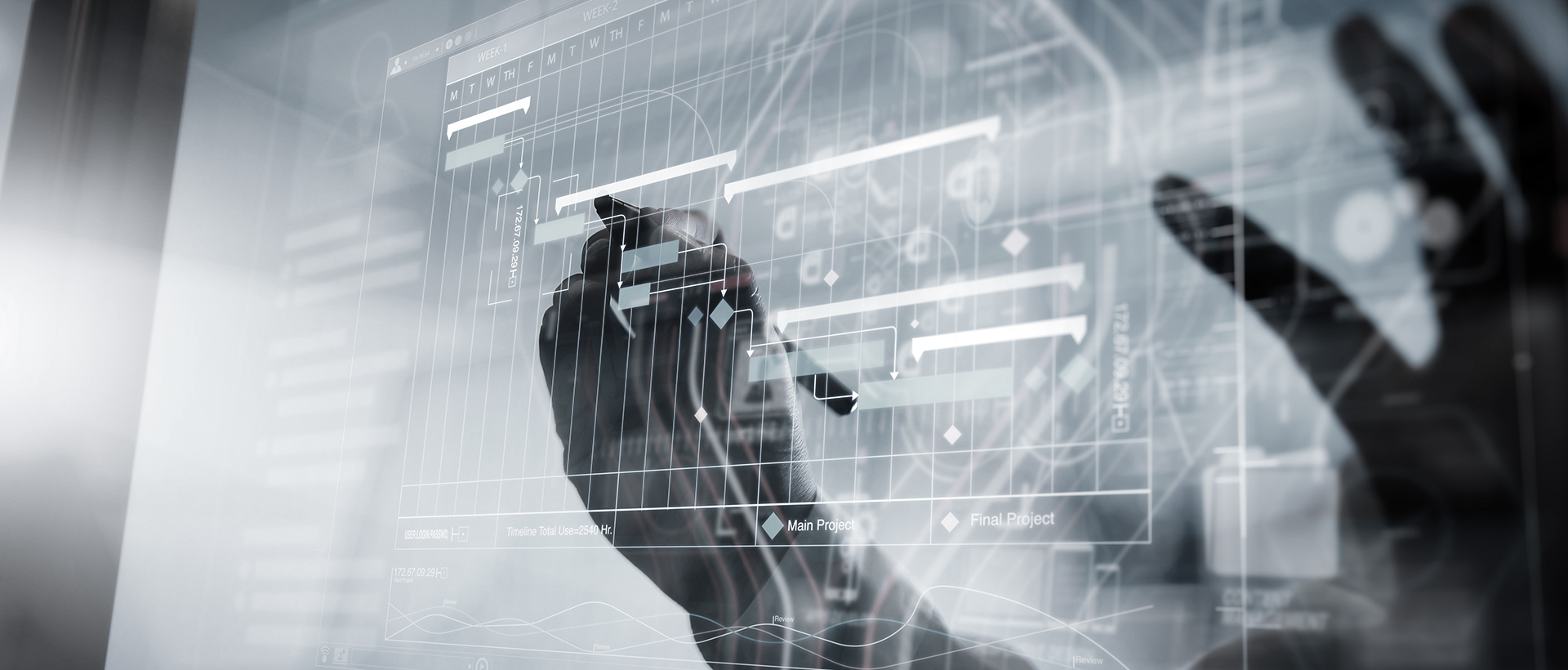 Mani che lavorano ad un GANTT di progetto su superficie touch di un computer